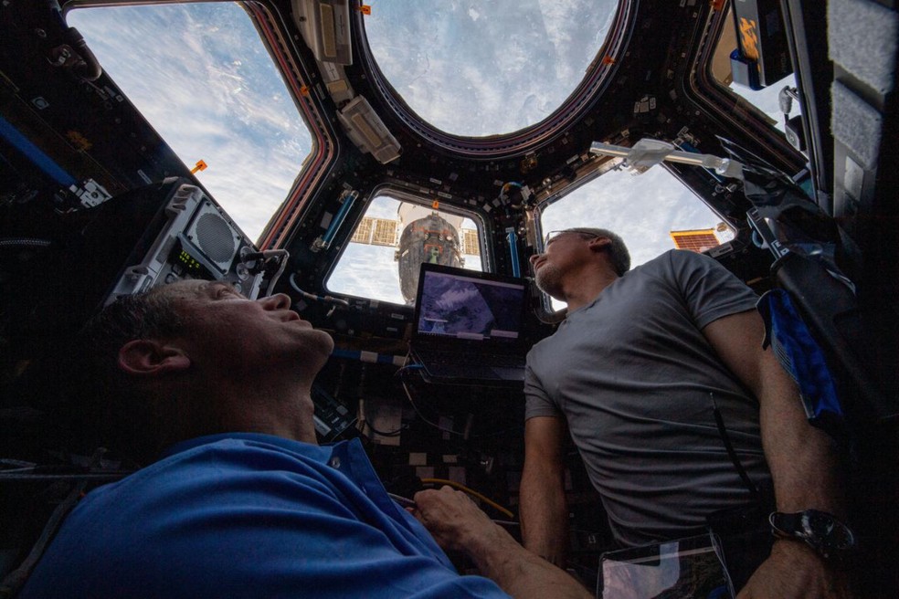 Astronautas observam a Terra pela janela da ISS — Foto: NASA