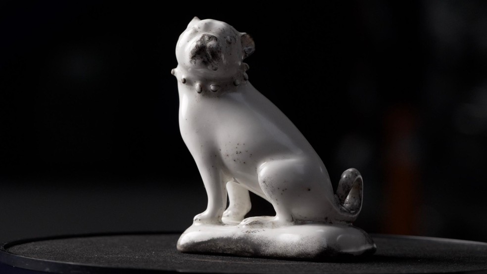Uma estatueta inteira de um pug sentado, feita de porcelana branca esmaltada, com detalhes em preto, encontrada em St James' Gardens, em Euston — Foto: BBC News fonte