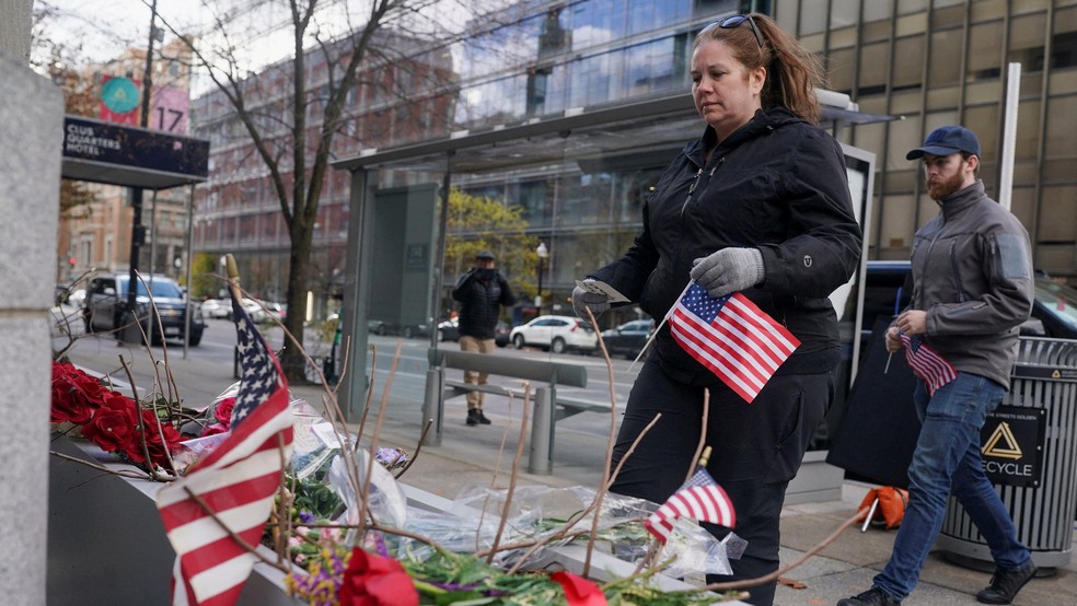 Moradores de Washington trazem bandeiras americanas para um memorial improvisado, em homenagem a dois membros da Guarda Nacional dos Estados Unidos baleados perto da Casa Branca na quarta-feira (26/11) — Foto: BBC News fonte
