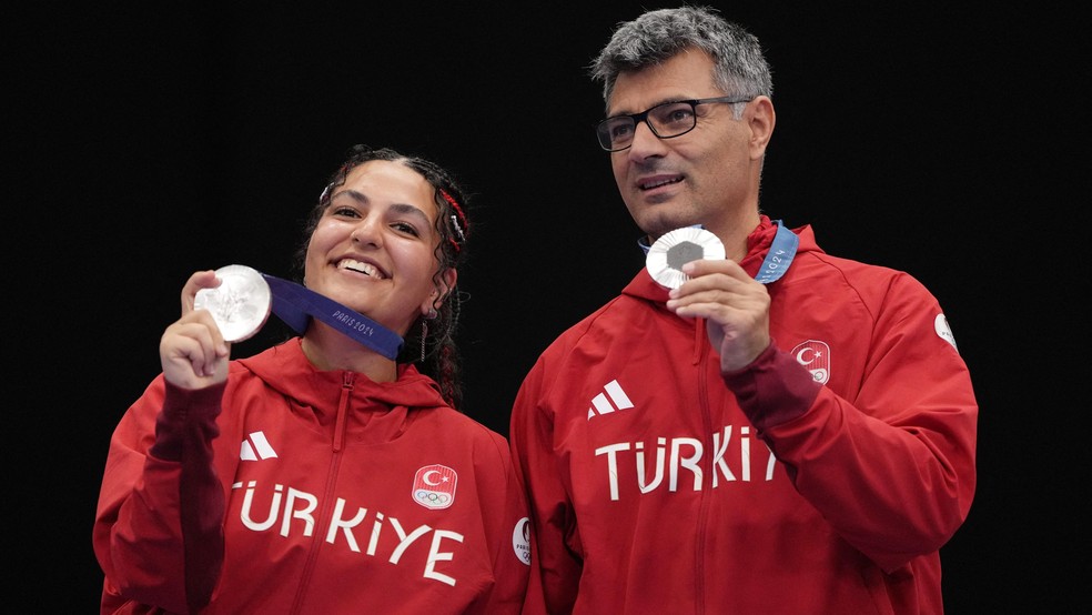 Fonte da BBC News - Foto: Os medalhistas de prata Sevval Ilayda Tarhan e Yusuf Dikeç da Turquia posam com suas medalhas