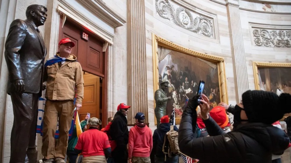 Em 6 de janeiro de 2021, manifestantes pr&oacute;-Trump destru&iacute;ram a &aacute;rea de prote&ccedil;&atilde;o e saquearam o Capit&oacute;lio dos EUA com o objetivo de impedir a certifica&ccedil;&atilde;o da elei&ccedil;&atilde;o. &mdash; Foto: BBC News fonte