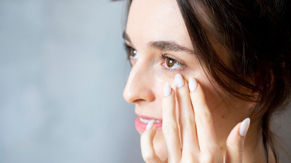 Mulher aplica creme na região dos olhos — Foto: BBC News fonte