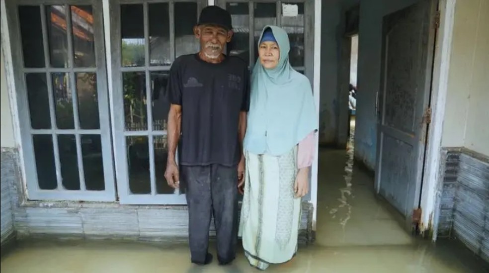 Suwandi e a mulher, Watini, em sua casa alagada em Eretan Wetan — Foto: Ayomi Amindoni/BBC