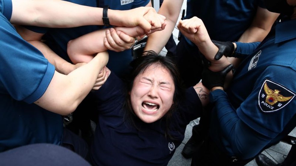 Manifestante na Coreia do Sul é presa pela polícia durante protesto contra o despejo das águas residuais da usina nuclear de Fukushima — Foto: Getty Images