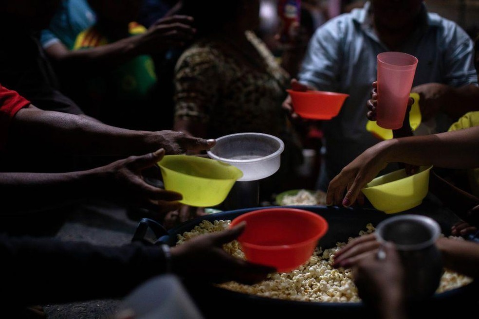 Refugiados venezuelanos recebem doação de alimentos em Pacaraima, Roraima — Foto: BBC News fonte