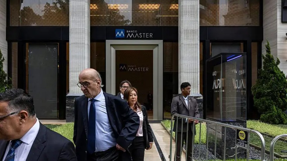 Funcionários do Banco Central deixam a sede do Banco Master em São Paulo, na terça-feira (18/11), após a prisão de Daniel Vorcaro, presidente-executivo do banco — Foto: Getty Images via BBC News