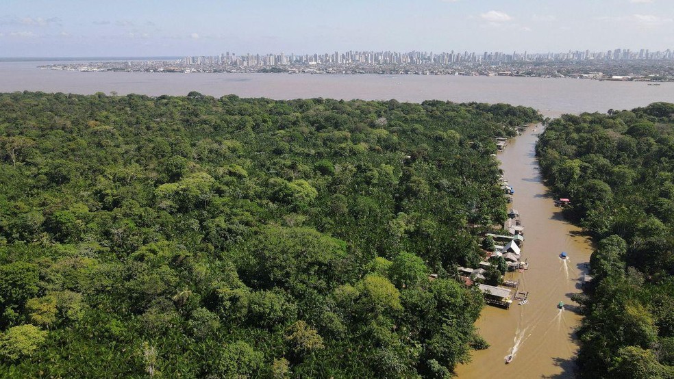 Uma imagem de drone mostra a floresta amazônica e a cidade de Belém ao fundo, antes da COP30, na Ilha do Combu, em Belém — Foto: BBC News fonte