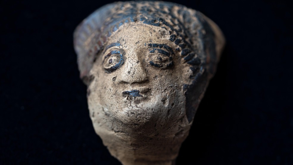 Uma cabeça de cerâmica destacada de um recipiente romano — Foto: BBC News fonte