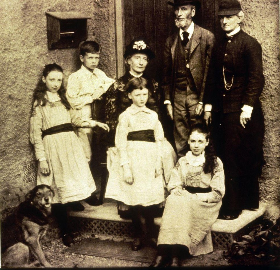 Eglantyne sentada no degrau da entrada da casa com a tia e outros familiares, em 1882 — Foto: BBC News fonte