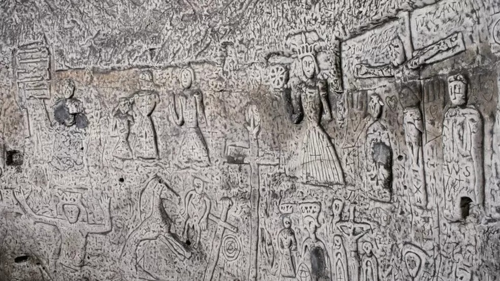 As paredes da caverna são escavadas de cima a baixo com estranhas figuras sem expressão — Foto: GETTY IMAGES via BBC