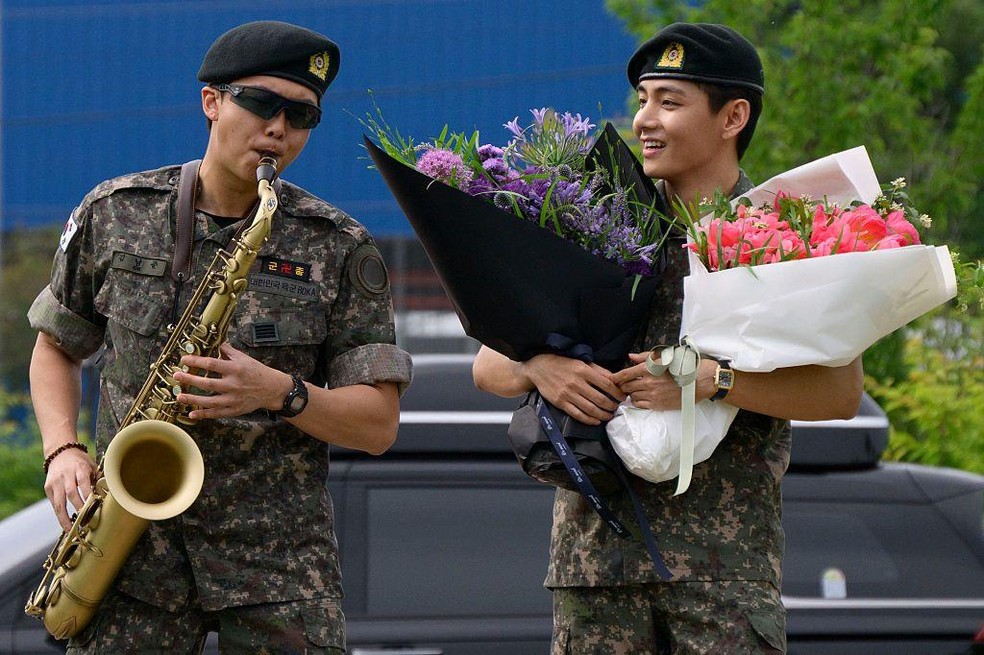 RM (à esquerda) e V (à direita) celebraram o fim do serviço militar em junho passado, pouco antes de Suga — Foto: BBC News fonte