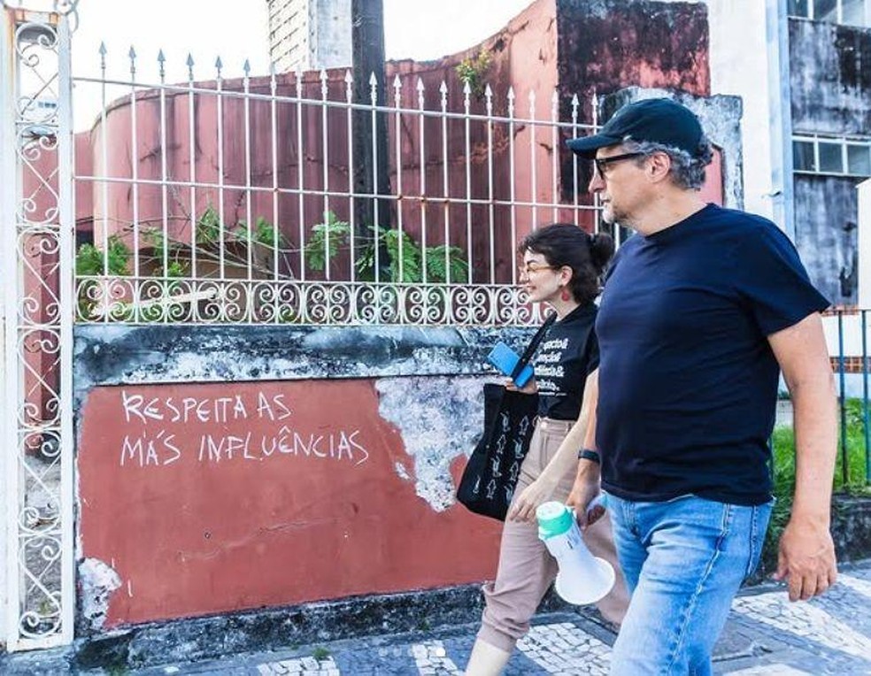 O diretor Kleber Mendonça Filho conduz passeio guiado por locais retratados em O agente secreto — Foto: BBC News fonte