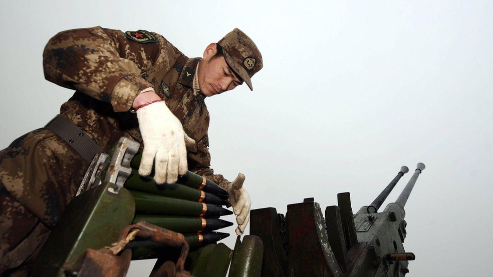 Um soldado carrega projéteis usados na semeadura de nuvens durante uma operação para combater a seca em Xigu Township, na Província de Shanxi, no norte da China, em fevereiro de 2011 — Foto: BBC News fonte