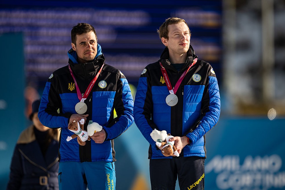 O medalhista de prata Maksym Murashkovskyi (à direita) e seu guia Vitaliy Trush, da equipe da Ucrânia, durante a cerimônia de premiação — Foto: Daniel Kopatsch/VOIGT/GettyImages