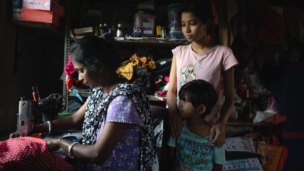 Soma Das usa o dinheiro para comprar materiais e confeccionar roupas, que ela vende para sustentar a família em Bengala Ocidental — Foto: BBC News fonte