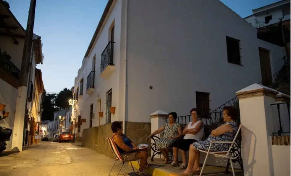 Algumas senhoras aproveitam o frescor da tarde em Arriate, em Málaga. A vida mais tranquila e com vínculos sociais mais fortes nos povoados é um dos motivos que levam cada vez mais pessoas a fazer a migração inversa — Foto: ORGE GUERRERO/AFP via Getty Images / BBC News