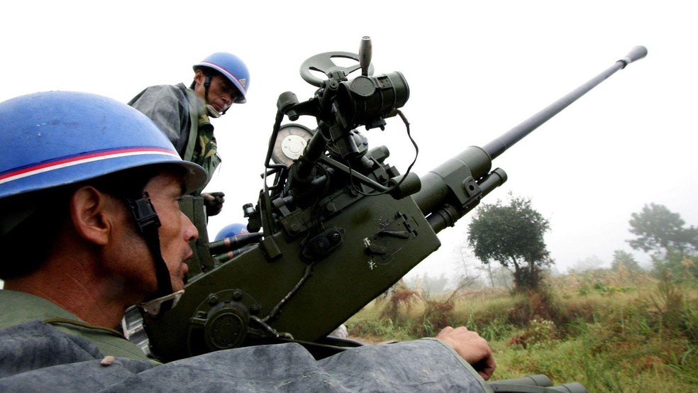 Funcionários do departamento meteorológico chinês se preparam para disparar projéteis de artilharia para semeadura de nuvens em Yongchuan, em 2009 — Foto: BBC News fonte