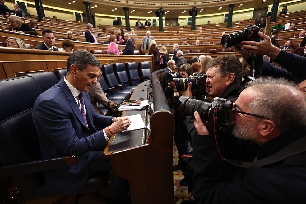 Sánchez aprovou a mais recente regularização de imigrantes sem passar pelo Parlamento, onde não tinha o apoio necessário — Foto: BBC News fonte