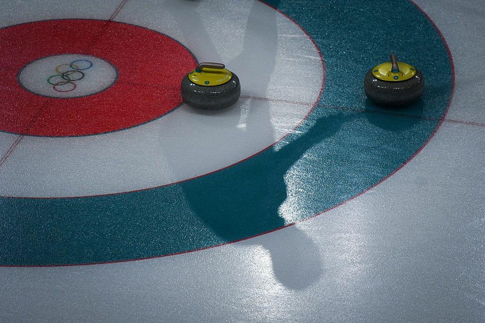 Uma pista de curling pode parecer lisa, mas a superfície é 'granulada' para reduzir o atrito entre a pedra e o gelo — Foto: BBC News fonte
