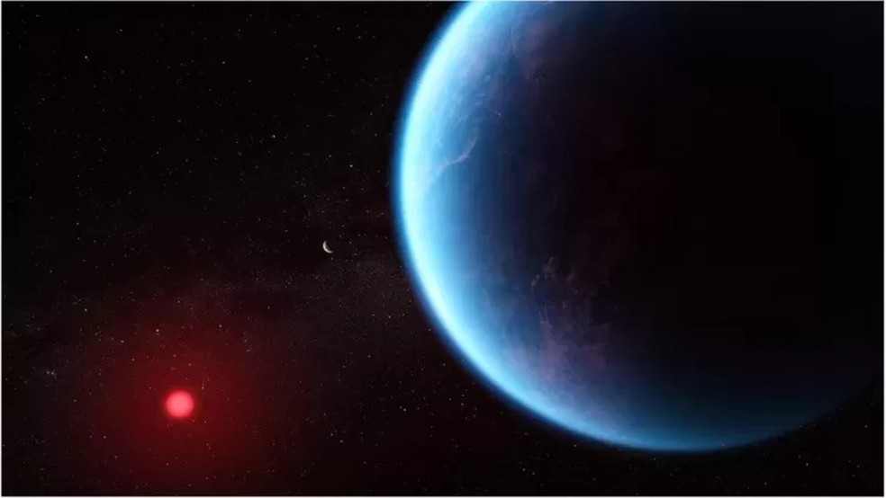 O K2-18 b orbita uma pequena estrela fria mostrada em vermelho, longe o suficiente para que sua temperatura suporte vida. — Foto: Nasa via BBC News